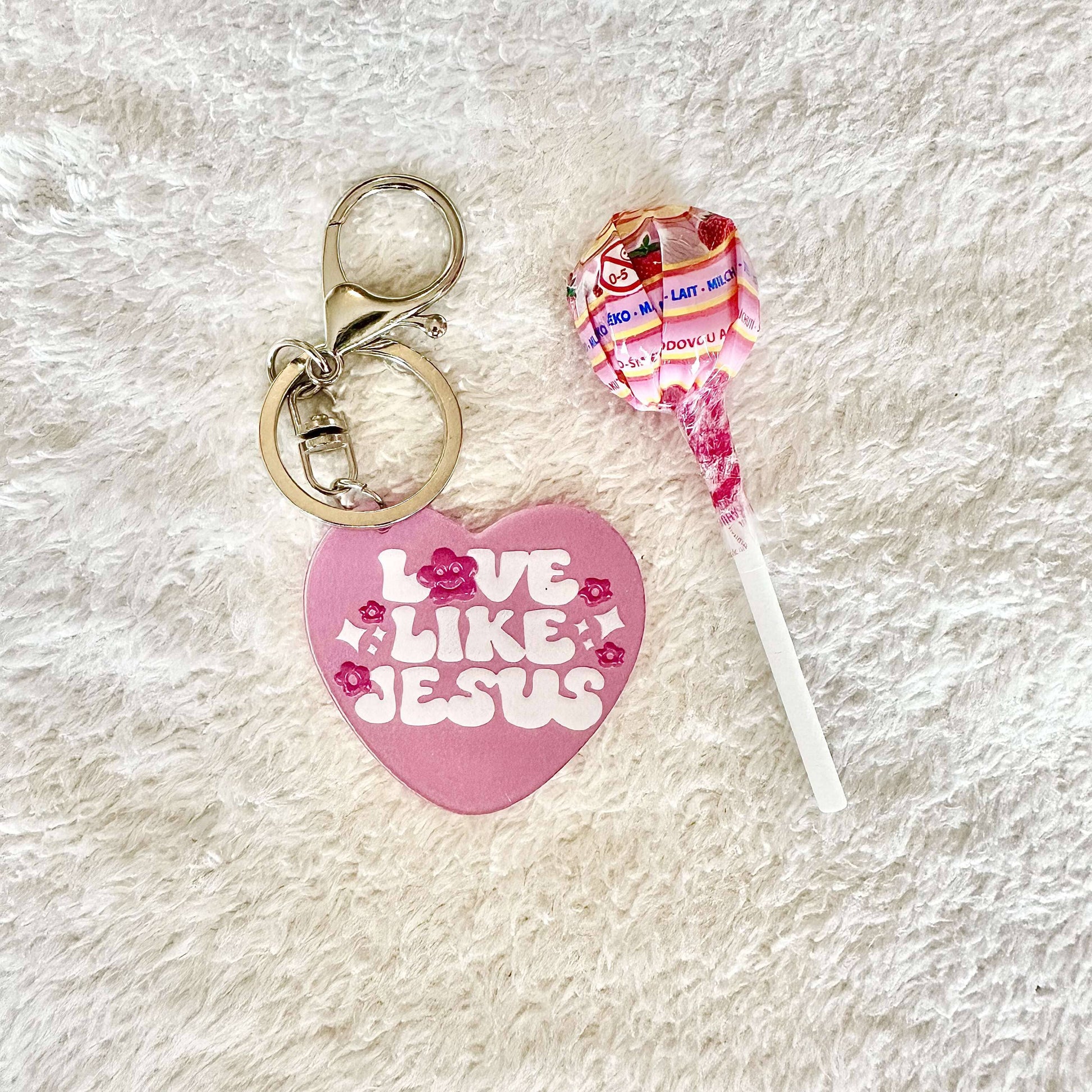 a pink heart formed Jesus keychain with a lollipop for christians